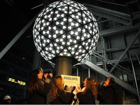 People cheer as the Times Square New Year's Eve ball is lit and raised (Credit: Ian Wallace)