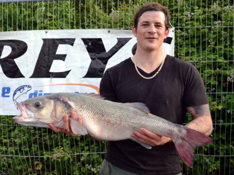 Angler Matt Clark, 29, poses with his 'winning' fish, a 13oz bass, that he stole from an aquarium in St Peter Port, Guernesy (Credit: Greg Whitehead)