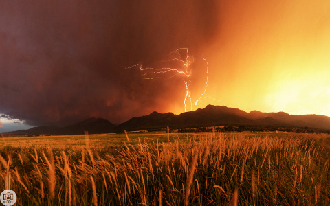 Shoot the Skies: day 224 of 365 - lightning above some peaks as seen across a field in Wallowa County  (Credit: Tanner Wendell Stewart)