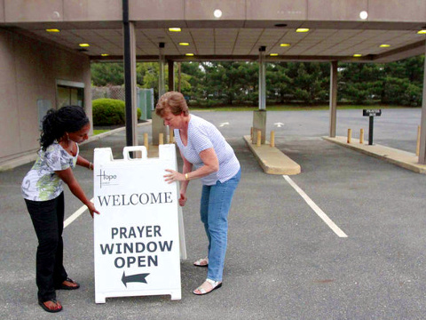 Open for prayer business: Moriam Okereke (left) and Marilyn Bills get ready for drive-through hours prior to opening the drive thru lane at Hope United Methodist Church in Voorhees, New Jersey on May 22, 2014 (Credit: Philadelphia Inquirer/Elizabeth Robertson)