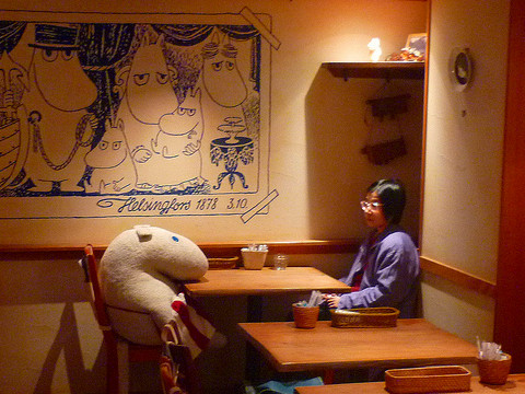 A lonely Japanese womans sits alone with a giant stuffed animal based on characters from the popular Moomin books from Finland in the Moomin Cafe in Tokyo, Japan, November 5, 2010 (Credit: Alícia Roselló Gené via Flickr)