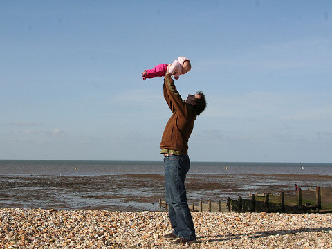 A father lifts his daughter above his head on Whitstable Beach in Kent, UK (Credit: Archangledeb via Flickr)