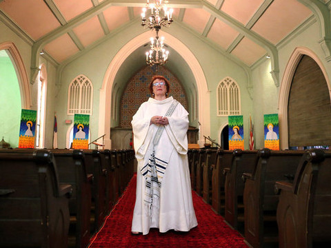 Lillian Lewis poses for a photo in an alb and stole inside the First Congregational Church in Three Oaks, Michigan in advance of her ordination as a Roman Catholic Womanpriest (Credit: MLive.com/Julie Mack)