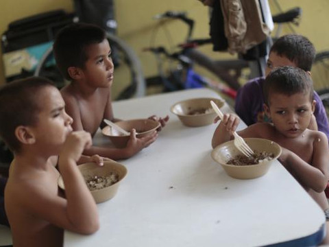 Children from Honduras, who will be accompanied by their families when they travel to reach northern Mexico or the U.S., have their meals at the Todo por ellos (All for them) immigrant shelter in Tapachula, Chiapas, Mexico, June 26, 2014. (Credit: Reuters/Jorge Dan Lopez)