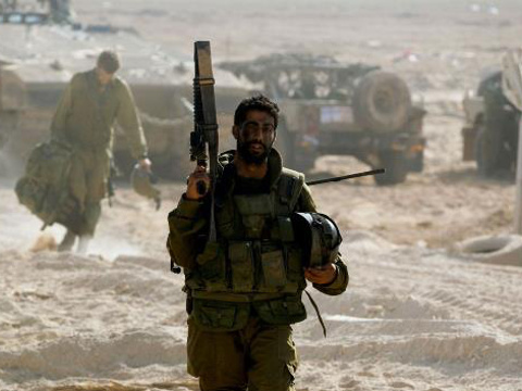 An Israeli soldier carries a weapon near the border with the Gaza Strip July 27, 2014 (Credit: Reuters/Ronen Zvulun)