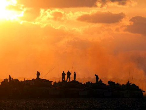 Israeli soldiers stand on top of their tanks and armoured personnel carriers (APCs) across from the northern Gaza Strip July 18, 2014 (Credit: Reuters/Baz Ratner)