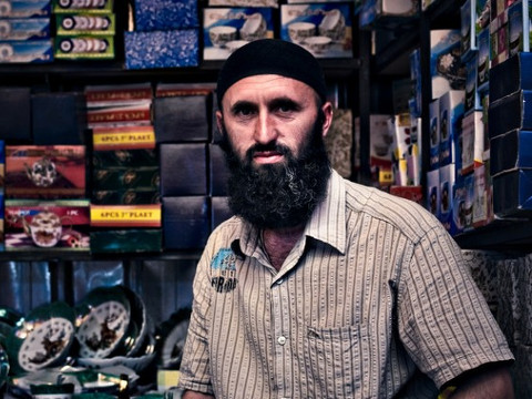 A Muslim shopkeeper from somewhere in the Middle East sitting on a chair in his clock shop (Credit: Trey Hill for East-West Ministries via Flickr)