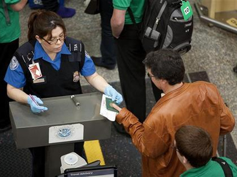 A Trasnportation Security Administration (TSA) employee checks the identification of passengers before they enter security screening at Reagan National Airport in Washington on May 2, 2011 (Credit: Reuters/Joshua Roberts)