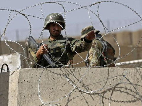 An Afghan National Army (ANA) soldier keeps watch at the gate of a British-run military training academy Camp Qargha, in Kabul August 5, 2014 (Credit: Reuters/Omar Sobhani)