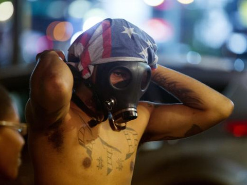 A protester dons a gas mask on West Florissant near Ferguson, Missouri August 18, 2014 (Credit: Reuters/Lucas Jackson)