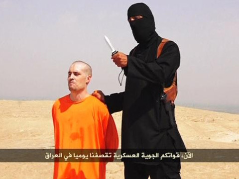 A masked Islamic State militant holding a knife speaks next to man purported to be U.S. journalist James Foley at an unknown location in this still image from an undated video posted on a social media website. (Credit: Reuters via Reuters TV)