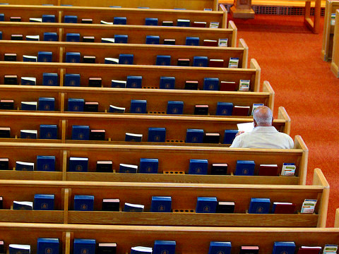 A man sits alone in a pew in a Presbyterian church as he awa…ice, September 8, 2012 (Credit: Quinn Dombrowski via Flickr)