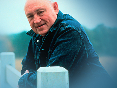 S Truett Cathy, Founder and Chairman of Chick-fil-A, wearing a denim jacket and leaning against a fence, poses for a photo at Rock Ranch, a beautiful 1,500 acre cattle ranch located about an hour south of Atlanta in Upson County dedicated to Growing Healthy Families (Credit: truettcathy.com)
