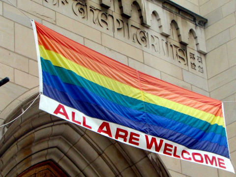 A rainbow banner, proclaiming all are welcome, hanging over the main entrance of the Church of the Pilgrims located at 2201 P Street, N.W., in the Dupont Circle neighborhood of Washington, D.C, used to send a message that homosexuals are welcome in the church, August 22, 2007 (Credit: Drama Queen via Flickr)
