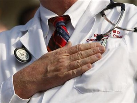 A doctor puts his hand over his chest during a House call rally against proposed healthcare reform legislation at the Capitol in Washington November 5, 2009 (Credit: Reuters/Kevin Lamarque)