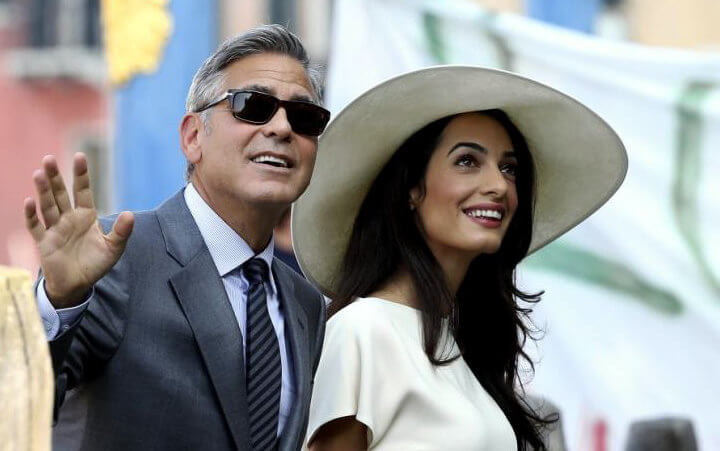 George Clooney and his wife, British lawyer Amal Alamuddin, arrive on Monday at the palazzo Ca'Farsetti in Venice for their civil ceremony, making them legally wed under Italian law, September 29, 2014 (Credit: Reuters/Alessandro Bianchi)