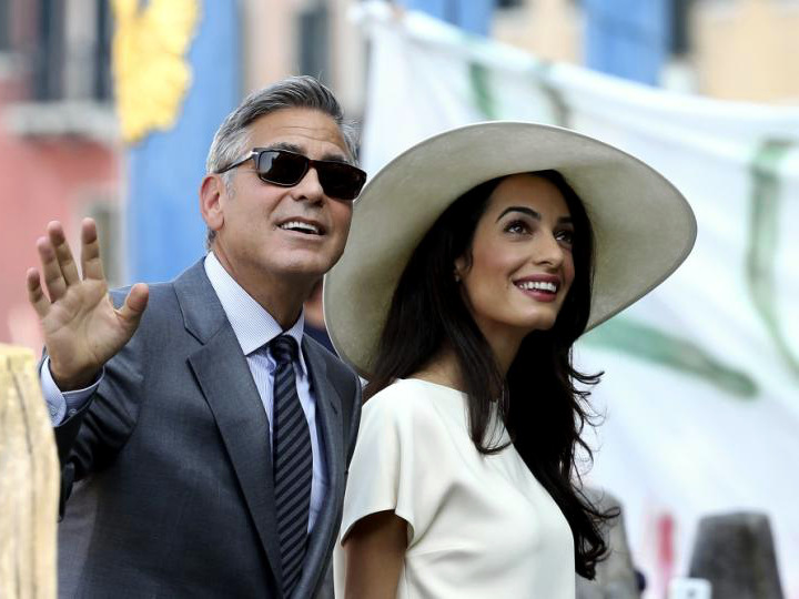 George Clooney and his wife, British lawyer Amal Alamuddin, arrive on Monday at the palazzo Ca'Farsetti in Venice for their civil ceremony, making them legally wed under Italian law, September 29, 2014 (Credit: Reuters/Alessandro Bianchi)
