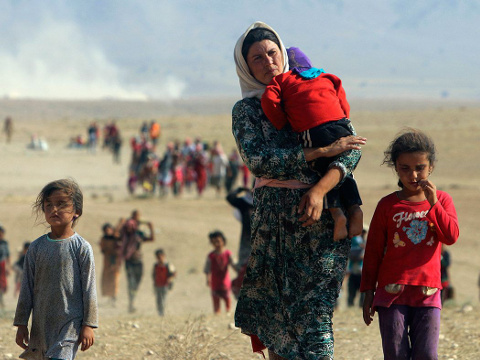 Displaced people from the minority Yazidi sect, fleeing violence from forces loyal to the Islamic State, walk toward the Syrian border near the town of Elierbeh of Al-Hasakah, on the outskirts of Sinjar Mountain, in northwest Iraq, August 11, 2014 (Credit: Reuters/Rodi Said)