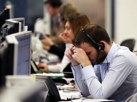 A worker on the IG Group's trading floor looks away from his screens in the City of London, October 4, 2011 (Credit: Reuters/Olivia Harris)