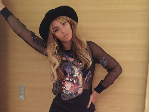 Beyonce leans against a wall wearing a black hat as she poses for a photo (Credit: Beyonce)