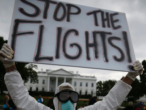 Protestor Jeff Hulbert of Annapolis, Maryland holds a sign reading 'Stop the Flights' as he demonstrates in favor of a travel ban to stop the spread of the Ebola virus, in front of the White House in Washington October 16, 2014 (Jim Bourg/Reuters)