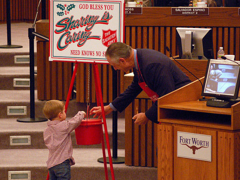 Salvation Army Red Kettle Presentation: Mayor Moncrief gets a little help from an audience member to kick off the 2010 Red Kettle Campaign (Credit: City of Fort Worth via Flickr)