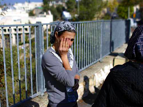 Ultra-orthodox Jewish women stand near the scene of a deadly attack carried out by two Palenstian men from the Jerusalem district of Jabal Mukaber against a Jewish synagogue in the ultra-Orthodox Har Nof neighborhood in west Jeruslem, November 18, 2014, Jerusalem, Israel (Credit: Reuters/Finbarr O'Reilly)