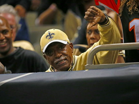 New Orleans Saints fan, Tony Williams, gives a thumbs down after taking a football away from Cincinnati Bengals fan, Christa Barrett, which Bengals tight end Jermaine Gresham tossed to her, after scoring a touchdown in the second half of an NFL football game in New Orleans, Sunday, November 16, 2014 (Credit: AP/Bill Haber)