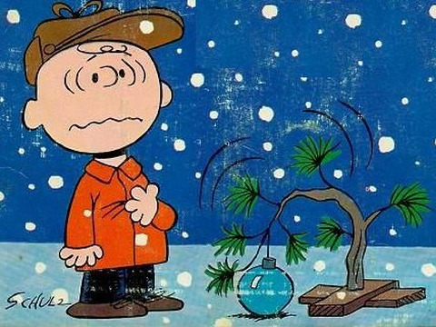 Charlie Brown standing beside his Christmas tree in A Charlie Brown Christmas, an animated musical television special based on the comic strip Peanuts (Credit: Charles M. Schulz)