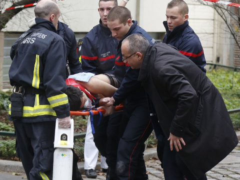 Firefighters carry a victim on a stretcher at the scene after a shooting at the Paris offices of Charlie Hebdo, a satirical newspaper, Paris, France, January 7, 2015 (Credit: Reuters/Jacky Naegelen)