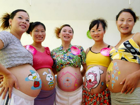 Pregnant women show off images on their stomachs, painted by an artist during a contest at a hospital in Haikou, in the Hainan Province, South China, August 07, 2006 (Credit: Reuters/ChinaFotoPress/Huang Yibing)