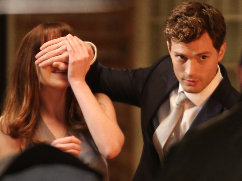Jamie Dornan as Christian Grey covers the eyes of Dakota Johnson, who plays Anastasia Steele, in a scene from the new Universal Pictures movie Fifty Shades of Grey (Credit: Universal Pictures/Focus Features)