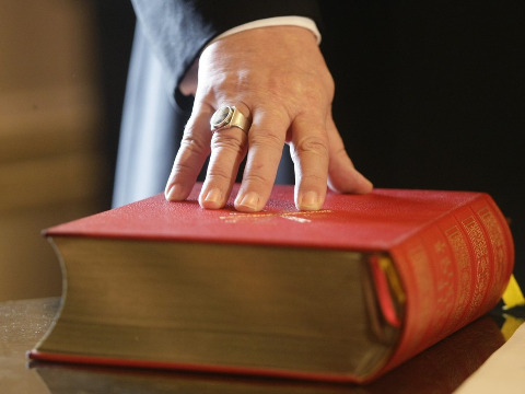 Reinhard Marx (L), new archbishop of Munich and Freising takes oath on the Bible during his inauguration ceremony in Munich, February 1, 2008 (Credit: Reuters/Michael Dalder)