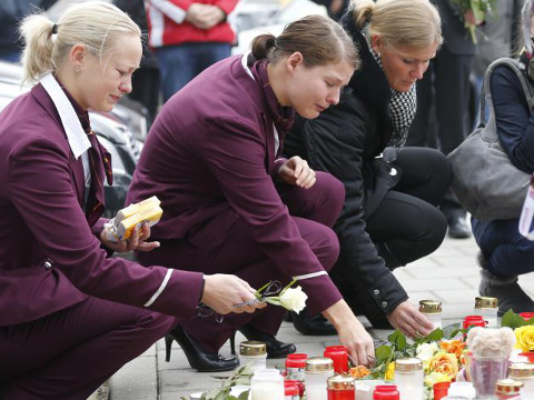 Germanwings employees cry as they place flowers and lit candles outside the company headquarters in Cologne Bonn airport, Germany March 25, 2015 (Credit: Reuters/Wolfgang Rattay)