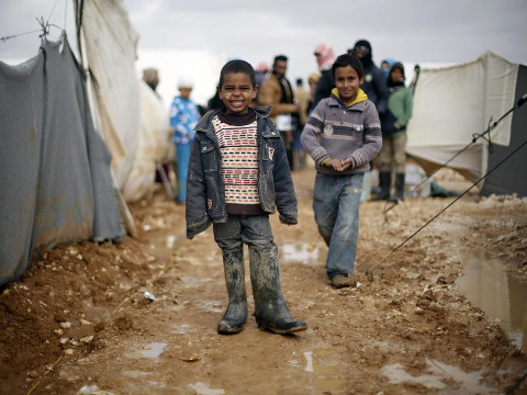 Syrian refugees children play near their family tent at Al Zaatari refugee camp in the Jordanian city of Mafraq, near the border with Syria, January 15, 2015 (Credit: Reuters/Muhammad Hamed)