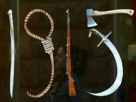 A woman is reflected in a display containing a banner depicting 'Tools of Genocide' forming the shape of '1915', in reference to the year of the mass killings of Armenians by Ottoman Turks, in Yerevan, April 22, 2015 (Credit: Reuters/David Mdzinarishvili)