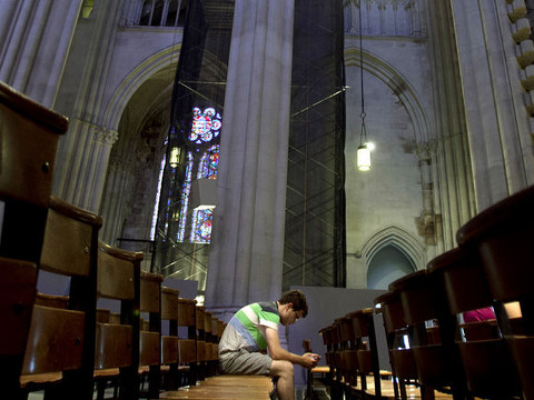 A man sits in the pews of Cathedral of St. John the Divine in New York, June 25, 2013 (Credit: Reuters/Carlo Allegri)