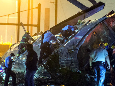 Rescue workers climb into the wreckage of a derailed Amtrak train to search for victims of an Amtrak passenger train wreck that killed six people and injured scores others as investigators sought to determine the cause of the derailment in Philadelphia, Pennsylvania May 12, 2015 (Credit: Reuters/Bryan Woolston)
