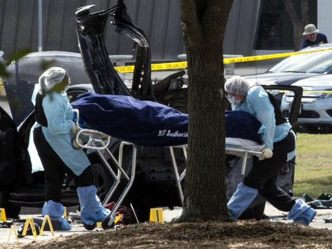 The bodies of two gunmen are removed from behind a car during an investigation by the FBI and local police in Garland, Texas May 4, 2015. (Credit: Reuters/Laura Buckman)