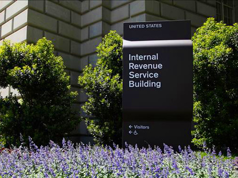 A view of an ugly brown sign outside the United States Internal Revenue Service building with spring flowers blooming in foreground, Washington DC, May 14, 2013 (Credit: Reuters/Jonathan Ernst)