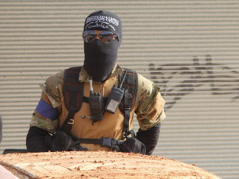 A member of al Qaeda's Nusra Front stands behind a vehicle before heading towards his position during an offensive to take control of Ariha May 28, 2015 (Credit: Reuters/Ammar Abdullah)