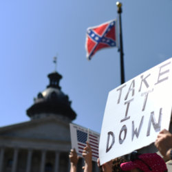 Protesters hold a sign during a rally to take down the Confederate flag at the South Carolina Statehouse, Tuesday, June 23, 2015, in Columbia, South Carolina, June 23, 2015 (Credit: AP Photo/Rainier Ehrhardt)