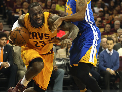 The Cleveland Cavaliers' LeBron James, left, has his drive to the basket cut off by the Golden State Warriors' Andre Iguodala during the first quarter in Game 4 of the NBA Finals at Quicken Loans Arena in Cleveland on Thursday, June 11, 2015 (Credit: Zuma Press/Icon Sportswire/Phil Masturzo)