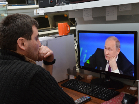 A customer watches Russian President Vladimir Putin on a computer screen in an electronic hypermarket in Grozny, regional Chechen capital, Russia, Thursday, December 18, 2014 (Credit: AP Photo/Musa Sadulayev)