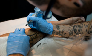 Tattoo artist working on a new project (Credit: LukaTDB via Fotolia)