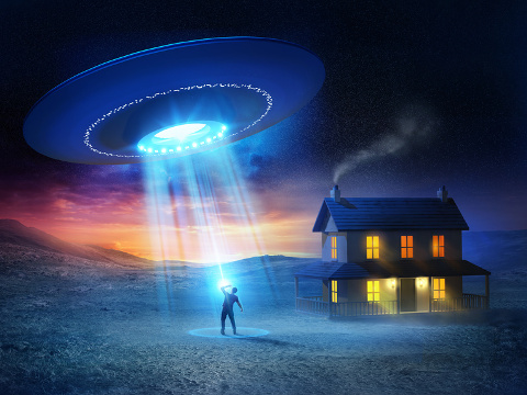 UFO abduction concept design showing a UFO abducting a person outside their home in the middle of nowhere (Credit: James Thew via Fotoli)