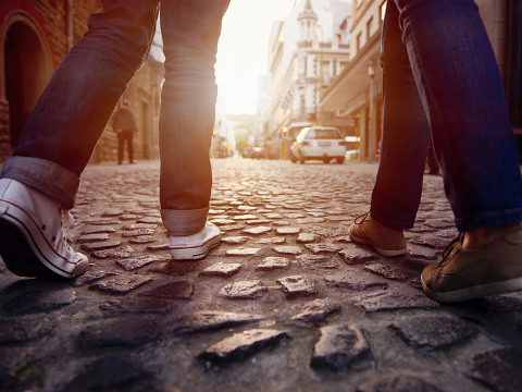 A young South African couple on vacation, walking along a cobblestone street, exploring a city in Europe (Credit: Warren Goldswain via Fotolia)