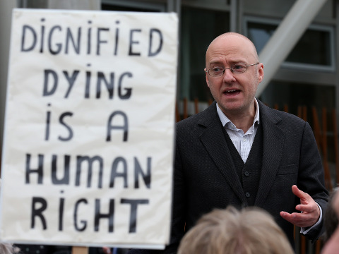 Assisted Suicide Bill supporter Patrick Harvie (centre), speaks with representatives of My Life, My Death, My Choice, outside the Scottish Parliament, as MSPs are due to debate the Assisted Suicide (Scotland) Bill, which would allow those with terminal or life-shortening illnesses to obtain help to end their suffering, May 27, 2015 (Credit: AP Images/Press Association/Andrew Milligan)