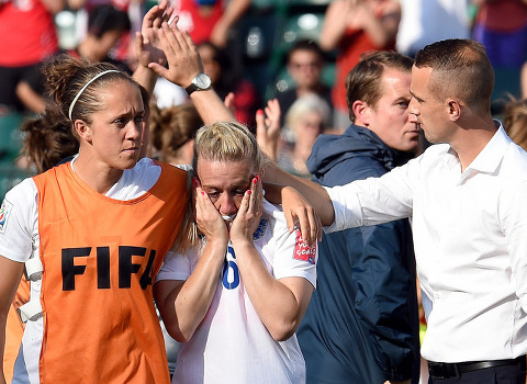 Laura Bassett (C), a defender on England's women's World Cup team, is comforted by England's head coach Mark Sampson (R) and teammate, Josanne Potter (L), afer Basset's own goal in the 90th minute lost the game for England during their semifinal match against Japan in 2015 FIFA Women's World Cup, Edmonton, Canada, July 1, 2015 (Credit: Icon Sportswire/Xinhua/Imago