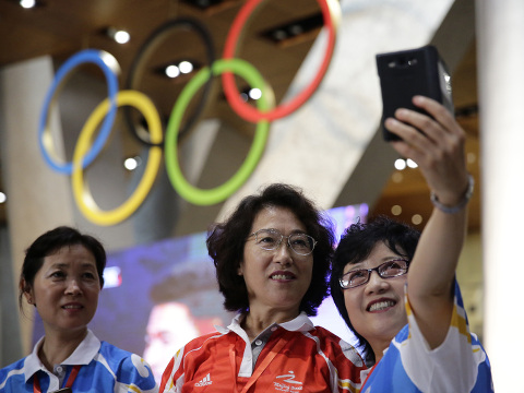Chinese Olympic fans take selfies to celebrate after Beijing was selected to host the 2022 Winter Olympics in Beijing, China, July 31, 2015 (Credit: AP Photo/ImagineChina/Bian Qing)